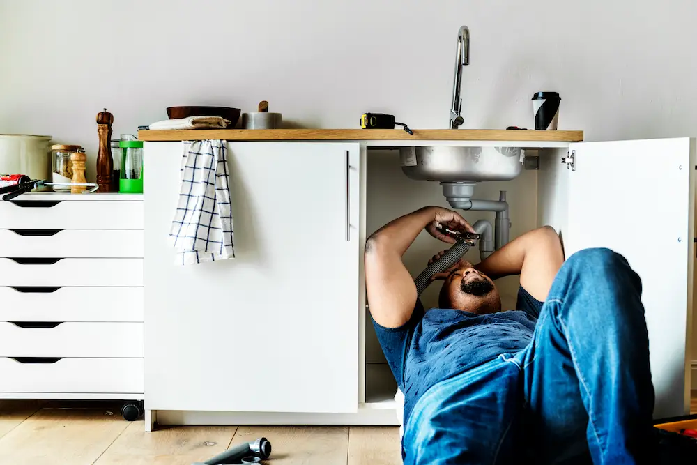 Plumber working under a sink